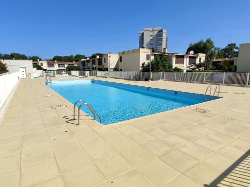 une grande piscine avec de l'eau bleue dans un immeuble dans l'établissement Studio rénové pour 4 pers avec piscine, tennis et parking privé à Argelès-sur-Mer, proche plage - FR-1-225-713, à Argelès-sur-Mer