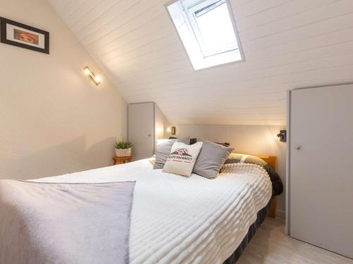 a bedroom with a large white bed with a skylight at Charmant appart. 4 pers. près de Saint Lary avec navette gratuite et forfaits ski! - FR-1-296-327 in Vielle-Aure