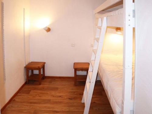 - une chambre avec des lits superposés et 2 tables dans l'établissement Appartement charmant avec piscine, sauna, et accès skis aux pieds - 6 personnes, Les Orres 1800 - FR-1-322-446, aux Orres