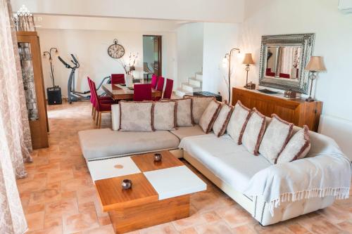 a living room with a couch and a table at Luxury Villa Hera - Beachfront in Roda
