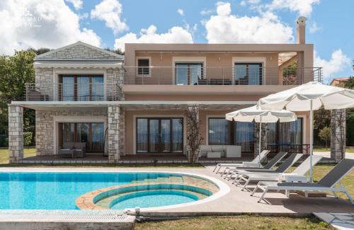 a villa with a swimming pool and a house at Luxury Villa Hera - Beachfront in Roda