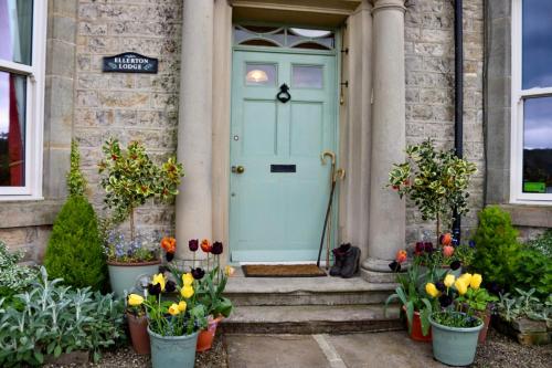 a blue front door of a house with flowers at Ellerton Lodge Bed and Breakfast Swaledale in Richmond