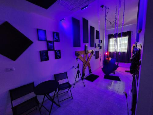 a purple room with chairs and a table and a microphone at Taboo21+ in Ashkelon