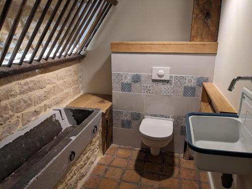 y baño con bañera, aseo y lavamanos. en La Grange de la Porterie - Magnificent House and Barn Conversion in Historic village, en Chapaize