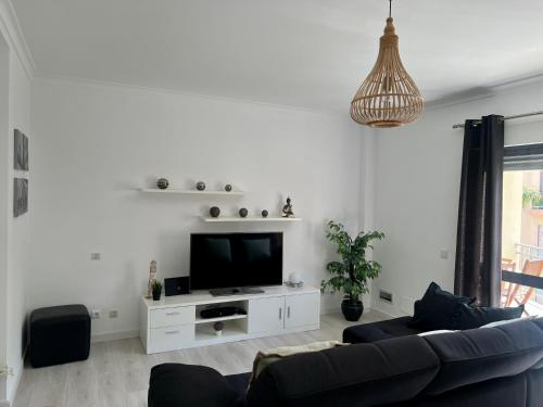 a living room with a couch and a tv at Ocean Drive in Sesimbra