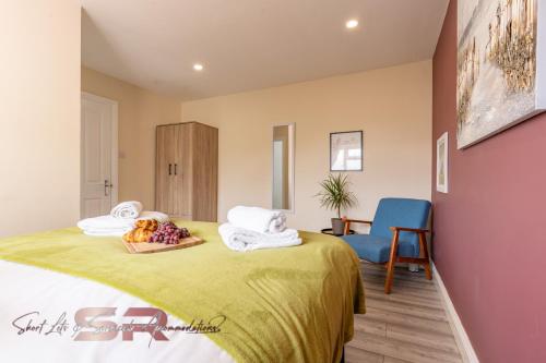 a room with a bed with a bowl of fruit on it at Rush House by SR Short Lets & Serviced Accommodation Heathrow Windsor - Perfect for Monthly Stay Relocation & Business Contractors Big Groups in Northolt