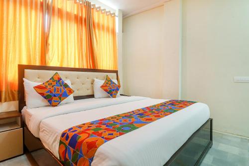 um quarto com uma cama grande e um edredão colorido em FabHotel Lotus Park em Visakhapatnam