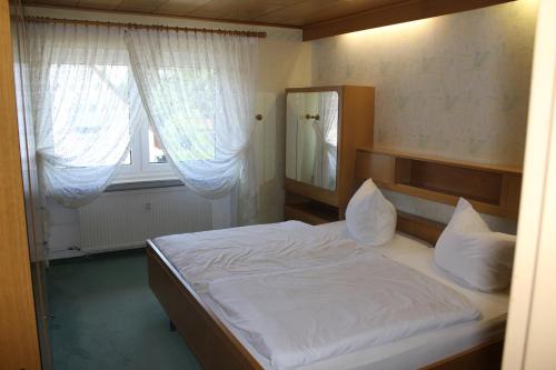 Schlafzimmer mit einem Bett, einem Spiegel und einem Fenster in der Unterkunft Ferienwohnungen am Playmobilpark in Oberasbach