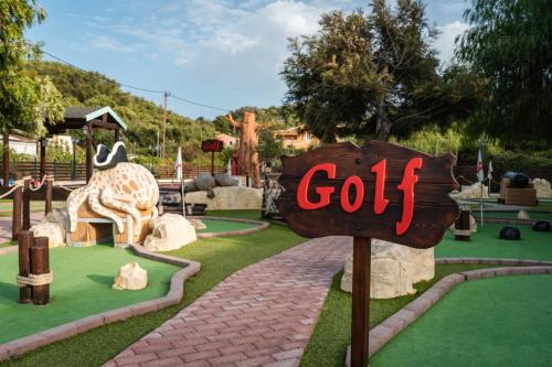 a sign that says golf in front of a giraffe at Neptune Sea House - Beachfront in St. Spyridon Corfu