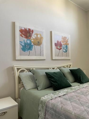 een slaapkamer met een bed met drie schilderijen aan de muur bij Lu Rizz- oasi di pace a pochi metri dalla piazza. in Ostuni