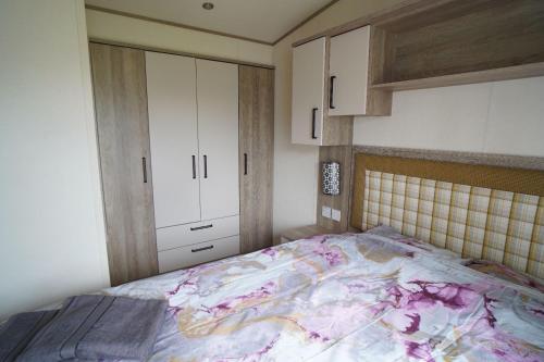um quarto com uma cama e armários brancos em Heacham Sunset lodge Platinum van em Hunstanton