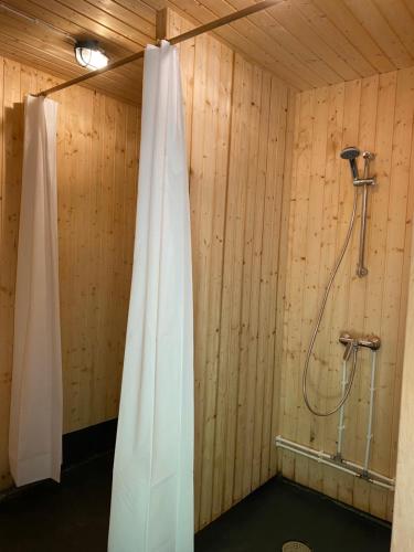 a bathroom with a shower in a wooden wall at Suurkivi Nature Escape in Häädemeeste