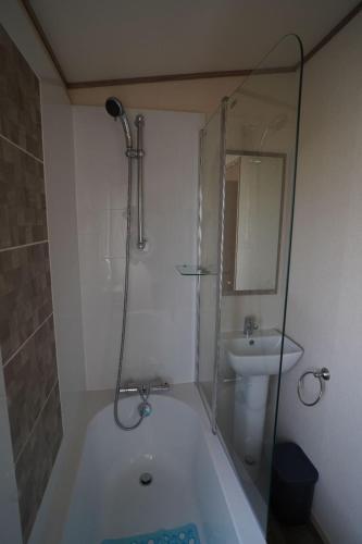 a bathroom with a shower and a tub and a sink at Stunning Heacham Sunset lodge pets go free linen included in Hunstanton
