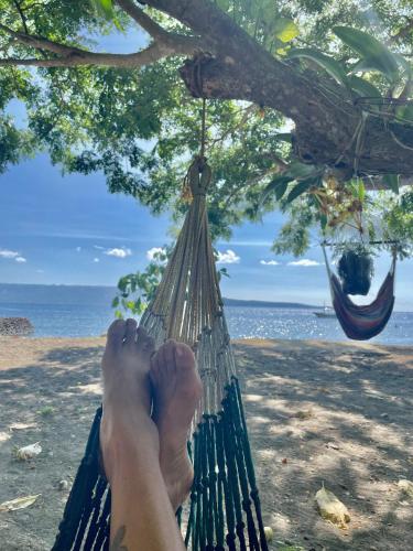 a persons feet in a hammock on a beach at Boochee Beach in Tampi