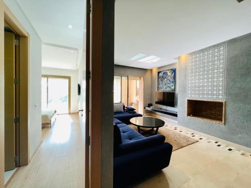 sala de estar con 2 sofás azules y chimenea en Corail Apart Golfique -Prestigia en Marrakech
