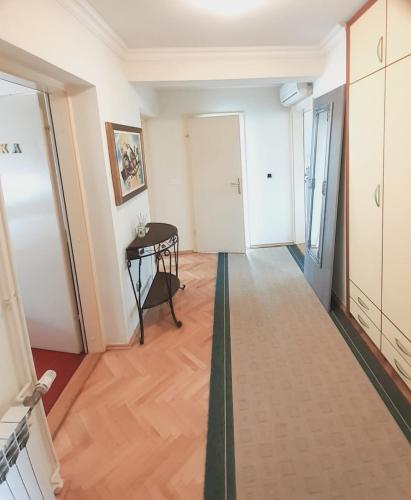 a corridor of a room with a table and a door at Spacious 80m2 Apartment in the Center in Ljubuški