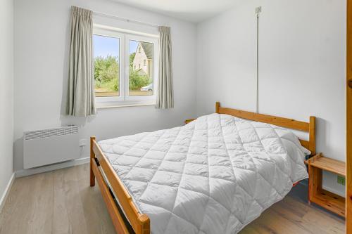 Habitación blanca con cama y ventana en Boreas Sunrise GV04, en Koksijde
