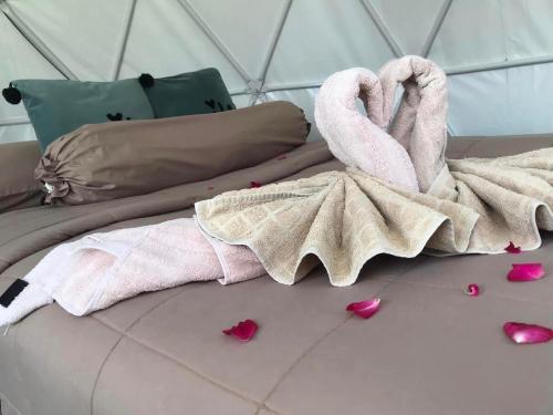 a bed with a pink blanket and hearts on the floor at สวนภูซีเขาค้อ in Ban Pa Daeng