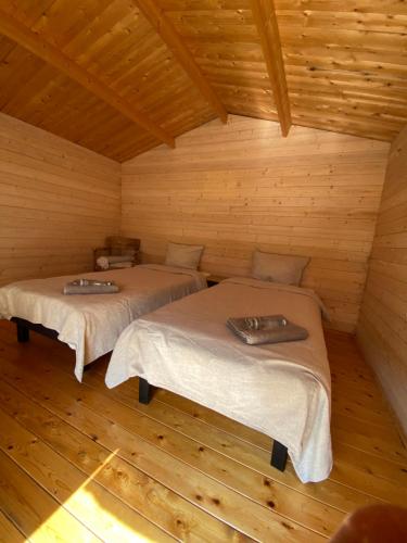 um quarto com duas camas num chalé de madeira em Suurkivi Nature Escape em Häädemeeste
