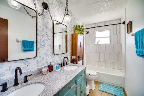 uma casa de banho com 2 lavatórios, uma banheira e um WC. em Palm Bay Vacation Rental with Private Pool! em Palm Bay