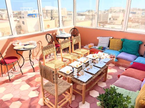 a living room with a table and chairs and a couch at Riad Dar Latigeo in Essaouira