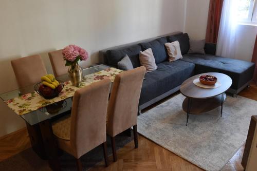 a living room with a blue couch and a table at Apartment Dimitrije in Budva