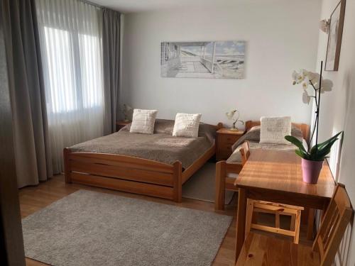 a small bedroom with two beds and a table at Dom Natura in Grzybowo