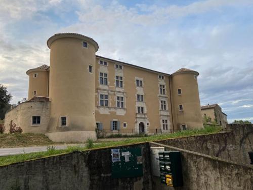 a large building on the side of a wall at Au pays de Gide appart feutré dans un château in Lussan