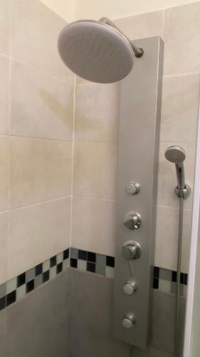 une salle de bain avec une douche avec pommeau de douche dans l'établissement Le Suffren, studio classé ventilé ,wifi, à 100 m de la plage, à Toulon