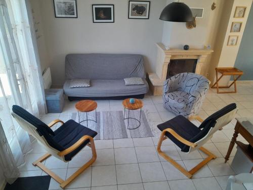 un salon avec un canapé, des chaises et une table dans l'établissement La Tribu d'Asato-Beauval 5 ch grand jardin et parking privé, à Noyers-sur-Cher