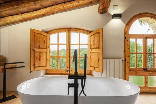 SerinyàにあるMas Cufíの窓付きの客室で、白い大型バスタブが備わります。