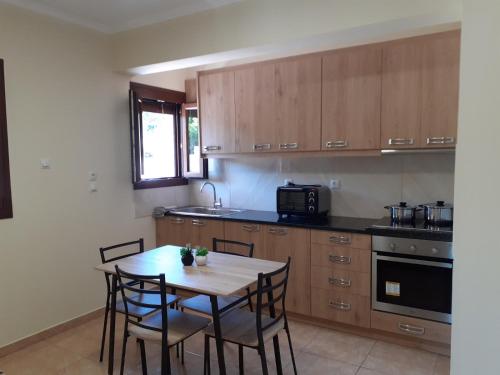 a kitchen with wooden cabinets and a table and chairs at Maria's home - Katelios in Katelios