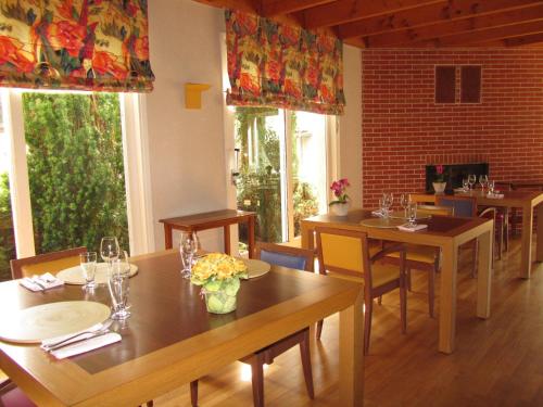 un restaurant avec des tables et des chaises en bois et des fenêtres dans l'établissement Auberge de l'Arzon, à Chomelix