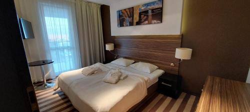 a hotel room with a bed with towels on it at Apartament 2 pokojowy prywatny z aneksem kuchennym w hotelu Diva in Kołobrzeg