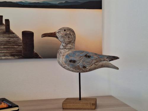 eine hölzerne Vogelstatue auf einem Stand in einem Raum in der Unterkunft Le Grigne Guest House in Oliveto Lario