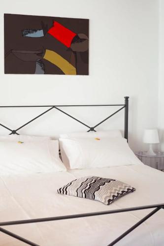 a bedroom with a white bed with a black frame at La Casina apartament in Ferrara