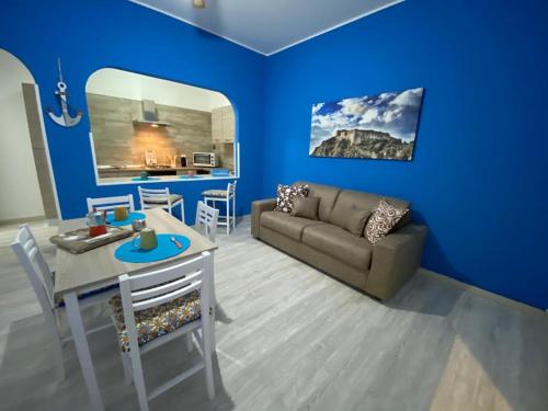 Sala de estar azul con sofá y mesa en Vista Eolie Milazzo- Apartments, en Milazzo