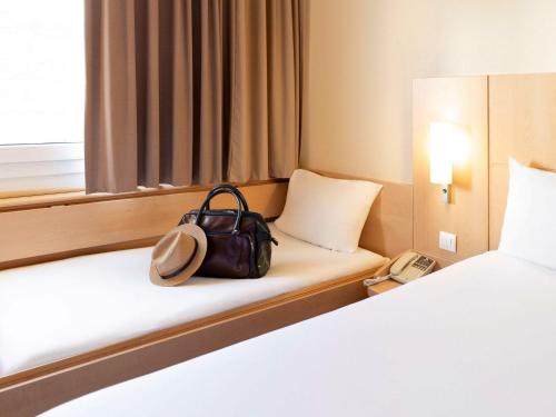 a bag sitting on a bed in a hotel room at Hotel Ibis Lisboa Sintra in Sintra