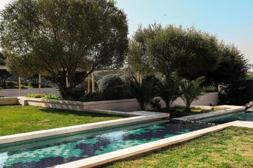 une piscine dans une cour avec des arbres en arrière-plan dans l'établissement JW Marriott Absheron Baku Hotel, à Baku