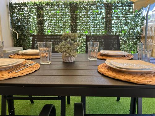une table en bois avec des assiettes et des serviettes dans l'établissement Green Oasis Apartment, à Alexandroúpolis