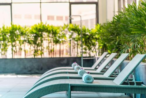 a row of green chairs sitting on a patio at Hotel Soleil Ha Long, Trademark Collection by Wyndham in Ha Long