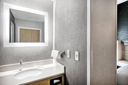 a bathroom with a sink and a mirror at SpringHill Suites Anchorage Midtown in Anchorage