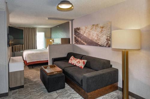a living room with a couch and a bed at SpringHill Suites Anchorage Midtown in Anchorage
