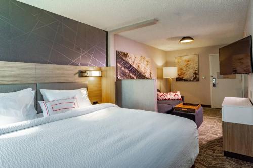 a hotel room with a large bed and a couch at SpringHill Suites Anchorage Midtown in Anchorage