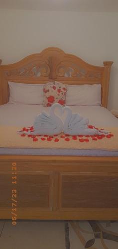 a bed with two towels and flowers on it at Grace Garden Guesthouse by Eminence Ent in Ocho Rios