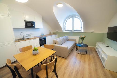 a kitchen and living room with a table and a couch at Luma Terra Prague Hostel in Prague