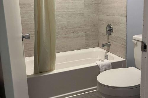 La salle de bains est pourvue de toilettes blanches, d'une baignoire et de toilettes. dans l'établissement Travelodge by Wyndham Carlisle North, à Carlisle