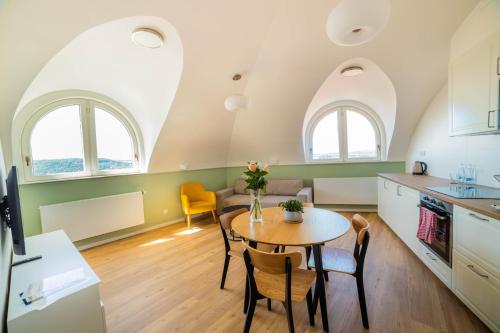 a kitchen and living room with a table and chairs at Luma Terra Prague Hostel in Prague