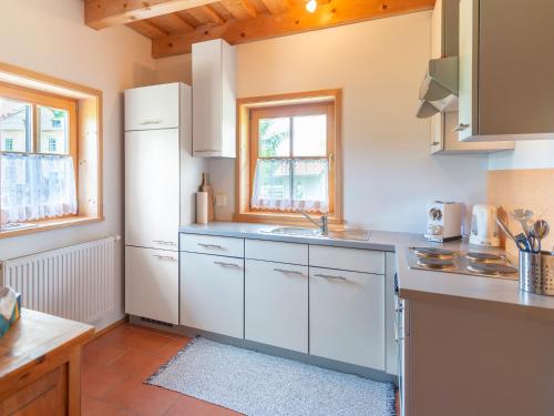 a kitchen with white cabinets and a white refrigerator at Berghütte - Chalet für 4-6 Personen - Schwarzenberg am Böhmerwald in Schwarzenberg am Bohmerwald