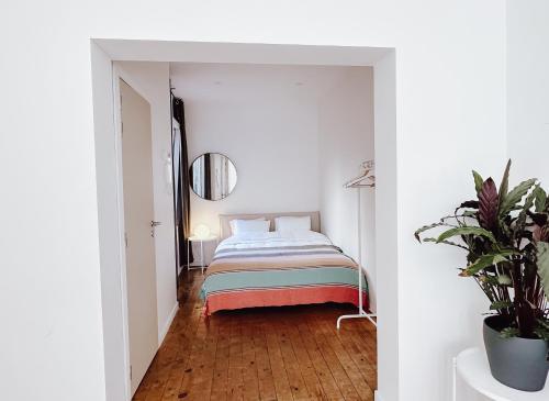 a bedroom with a bed in a white room at Studio Sur - Sea, Sun, City-Centre in Ostend